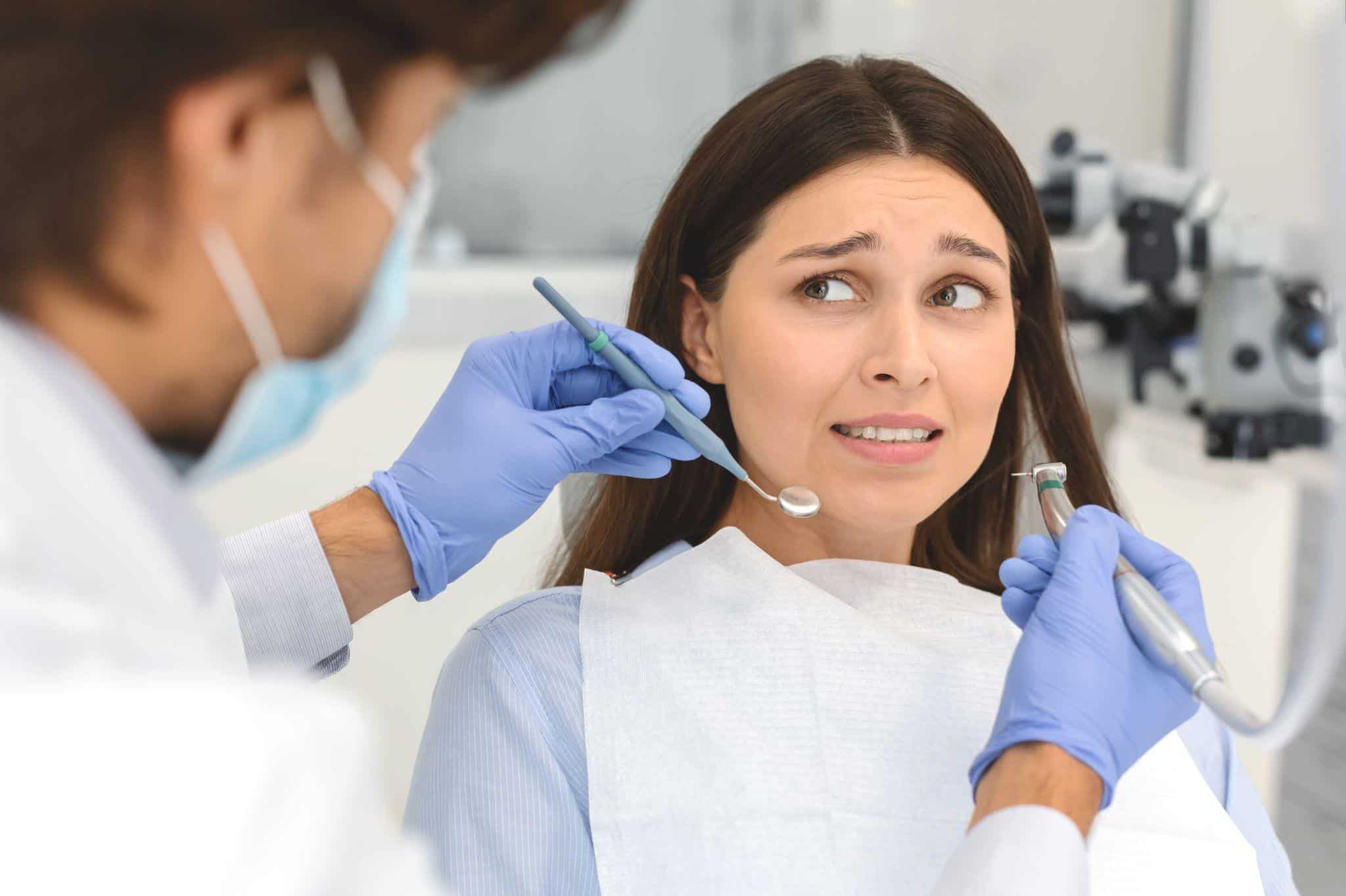 Scared young woman looking at dentist los angeles